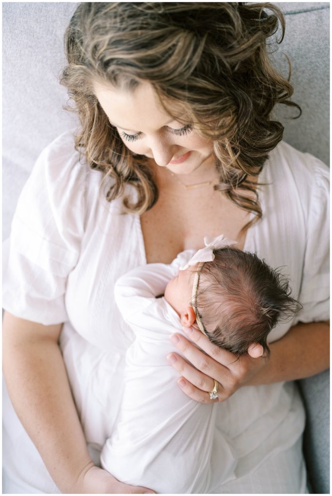 A mother holds her newborn. Alpharetta newborn photographer Grace Emily Photography documents beautiful moments between new parents and their babies.