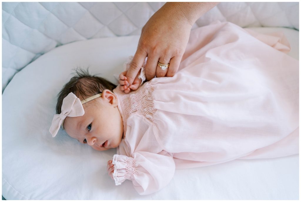 A newborn lays looking into the distance. Alpharetta Newborn photographer Emily Grace photography documents precious newborn moments.