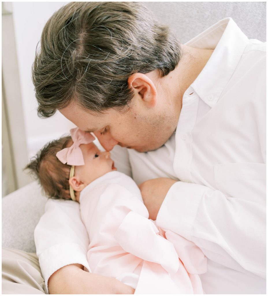 A father holds his newborn daughter, captured by Alpharetta Newborn Photographer Grace Emily Photography 