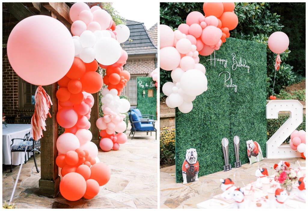 A red and white balloon arch around a door and grass wall for a two year old's University of Georgia birthday party.